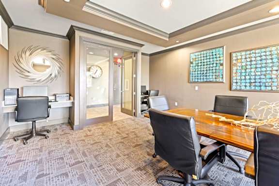 A conference room with a wooden table and chairs.