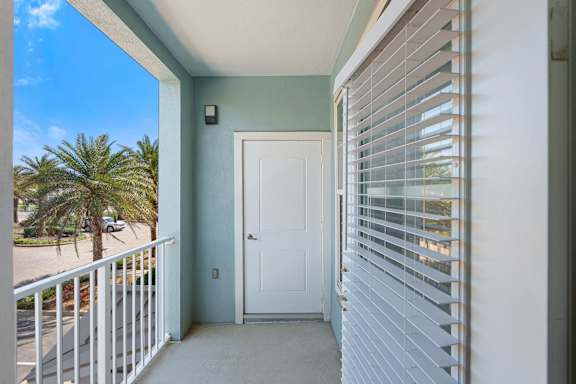 A balcony with a white door and a white railing.
