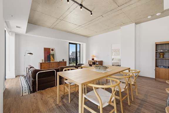 A dining room with a wooden table and chairs.