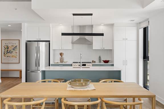 A modern kitchen with a wooden table and chairs.