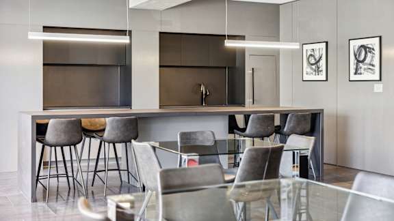 A modern kitchen with a bar area and chairs.