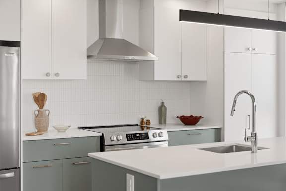 A modern kitchen with a stainless steel refrigerator and a white countertop.