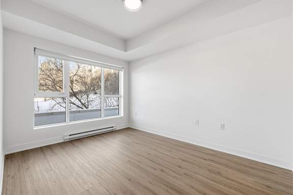 A room with a window overlooking a snowy landscape. at Château golf, Gatineau