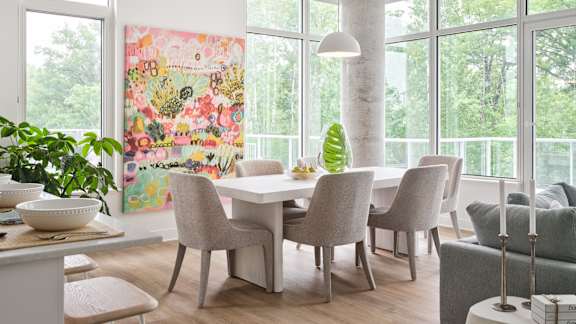 A dining room with a table and chairs and a painting on the wall. at Petries Landing I Apartments , Ontario