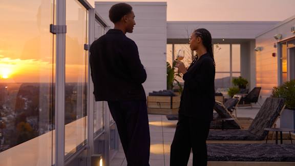 Two people standing outside a house at sunset. at Le ColumbiaApartments , Gatineau, Quebec