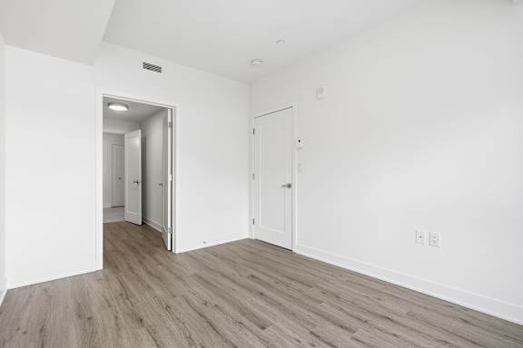 A room with a white wall and a wooden floor. at Château golf, Gatineau, QC J9H 0M9