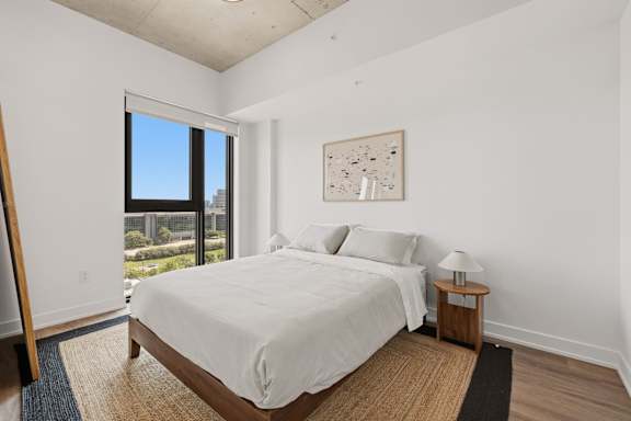 A bedroom with a large bed and a view of the city.