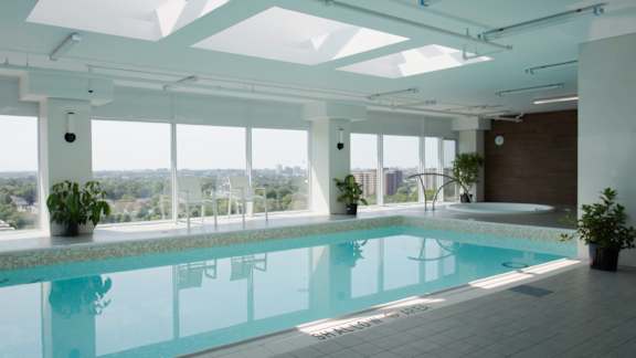 A large indoor swimming pool with a view of the city.