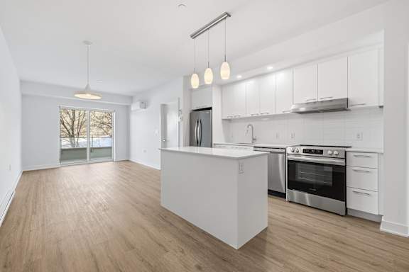 A modern kitchen with white cabinets and stainless steel appliances. at Château golf, Gatineau, QC