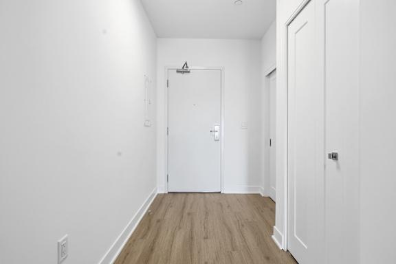 A white door is in the middle of a room with wood flooring. at Château golf, Gatineau, J9H 0M9