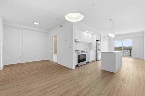 A spacious kitchen with a dining area and a large window. at Château golf, Quebec, J9H 0M9