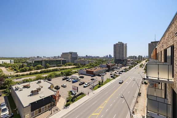 A city street with cars and buildings on either side.