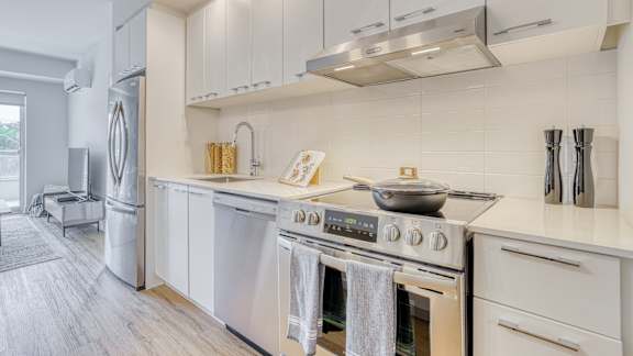 A modern kitchen with a stainless steel refrigerator and a stove top oven. at Château golf, Quebec