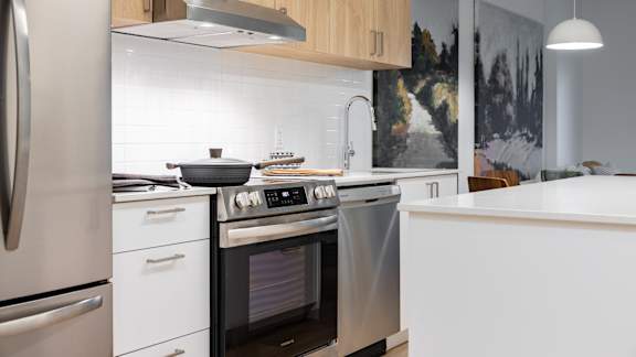 A modern kitchen with a stainless steel oven and white cabinets. at Petries Landing I Apartments , Ottawa