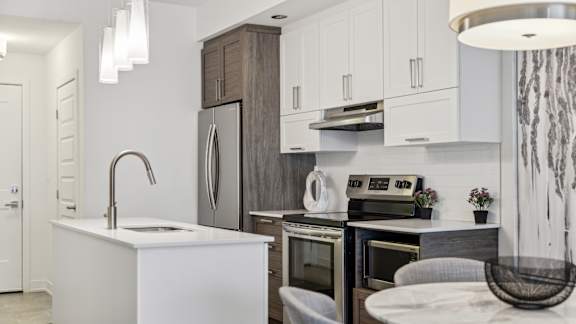 Modern kitchen with white cabinets and island at Horizon Apartments, Gatineau, QC
