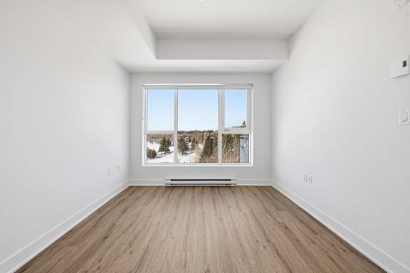 A room with a large window overlooking a snowy landscape. at Château golf, Gatineau, J9H 0M9