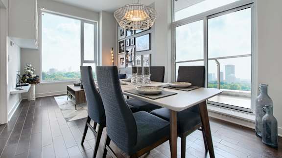 A dining room with a table set for four and a view of the city.