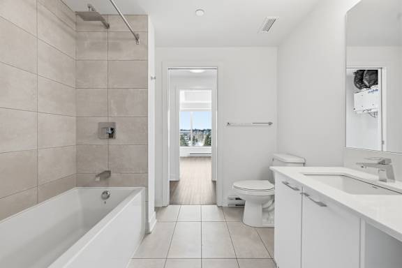 A bathroom with a white tub, toilet, and sink. at Château golf, Quebec, J9H 0M9