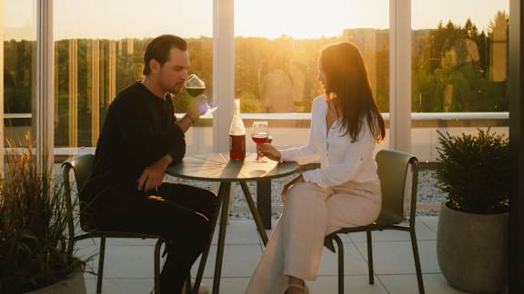 A man and a woman are sitting at a table with drinks, enjoying a conversation. at Château golf, Quebec, J9H 0M9?