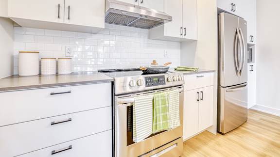 A kitchen with a stove top oven and a refrigerator.