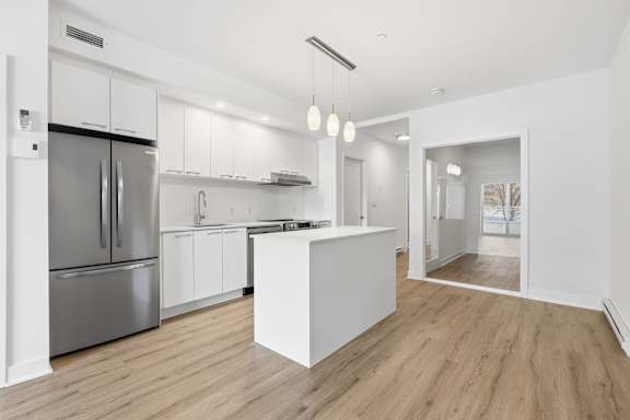 A modern kitchen with a refrigerator, cabinets, and a countertop. at Château golf, Gatineau Quebec