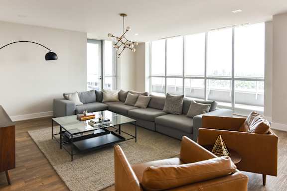 A living room with a green armchair and a white sofa.