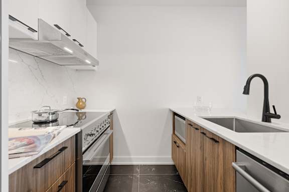 A kitchen with a stove, oven, and sink.