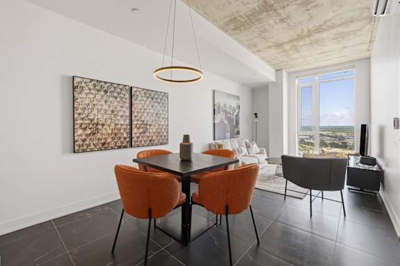 A modern dining room with a large window and a view of the ocean.