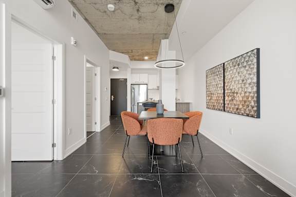 A dining room with a table and chairs.