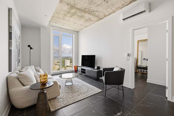 A living room with a couch, a chair, a coffee table, and a television.