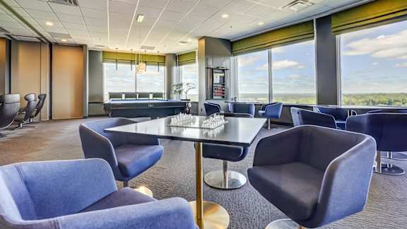 A conference room with blue chairs and a table with a glass top.