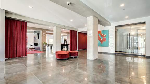 Modern lobby with red curtains and seating at Horizon Apartments, Gatineau, J9A 0G9