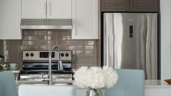 Modern kitchen with white cabinetry and tile backsplash at Kanata Lakes Apartments, Ontario, K2T 0K3