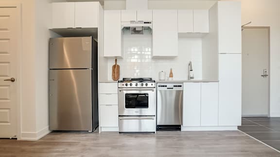 A modern kitchen with a stainless steel refrigerator and oven.