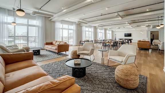 A modern living room with leather chairs and a coffee table.