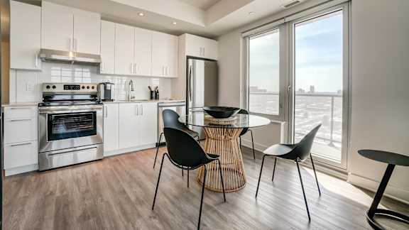 A modern kitchen with a dining table and chairs at The Dale Apartments , Ottawa, Ontario