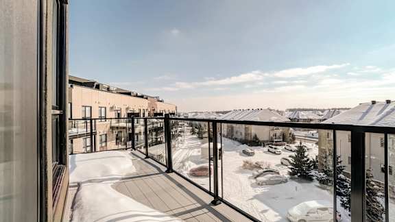 Winter balcony with glass railing overlooking courtyard at Horizon Apartments, Quebec