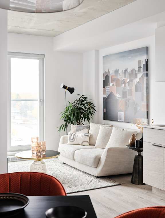 A living room with a white couch and a large window.
