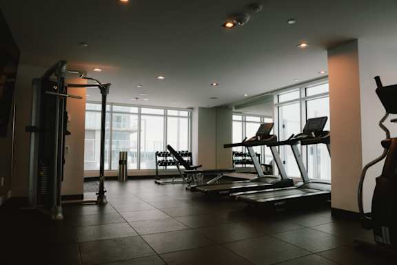 A man is lifting a barbell in a gym.