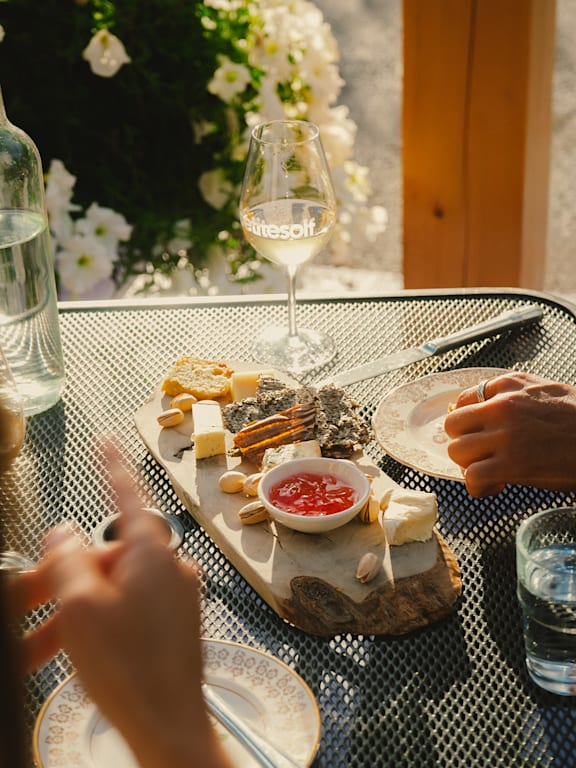 A man and a woman are sitting at a picnic table playing a game with letter tiles.