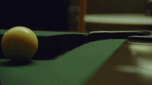 A pool table with a white ball on it.