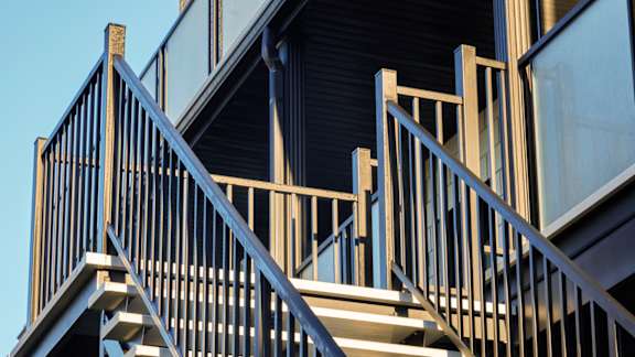 A staircase with a metal railing and wooden steps.