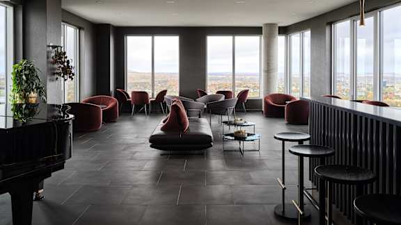 A grand piano sits in a room with a view of the city at The Dale Apartments , Ottawa, K1Y 4Y5