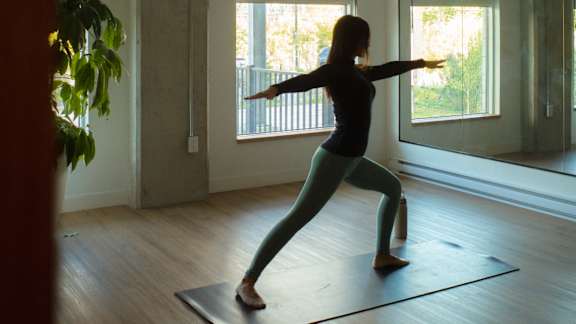 A woman is practicing yoga in a room with a large window. at Château golf, Quebec