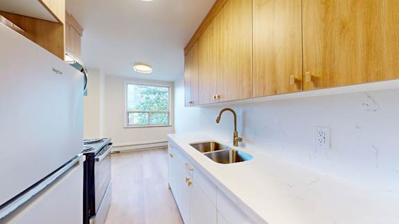 A kitchen with wooden cabinets and a white fridge.
