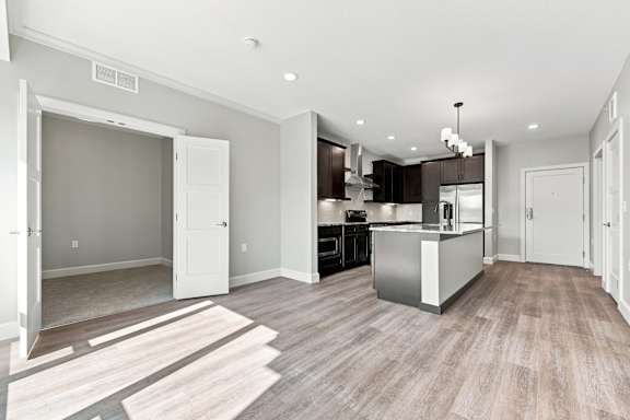 A modern kitchen with a wooden floor and white walls.