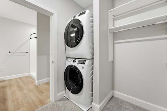 A white front loading washing machine in a laundry room.
