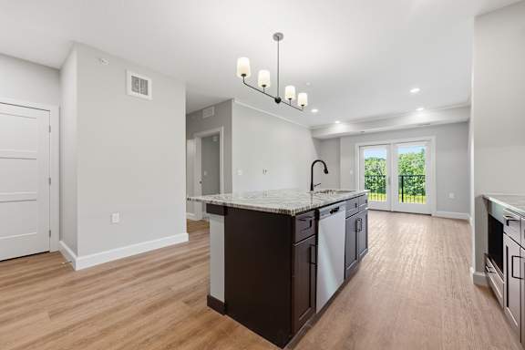 A kitchen with dark wood floors and white walls.