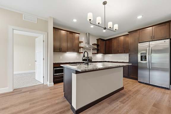 A kitchen with a center island and stainless steel appliances.