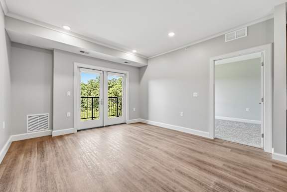 A room with a sliding glass door leading to a balcony.